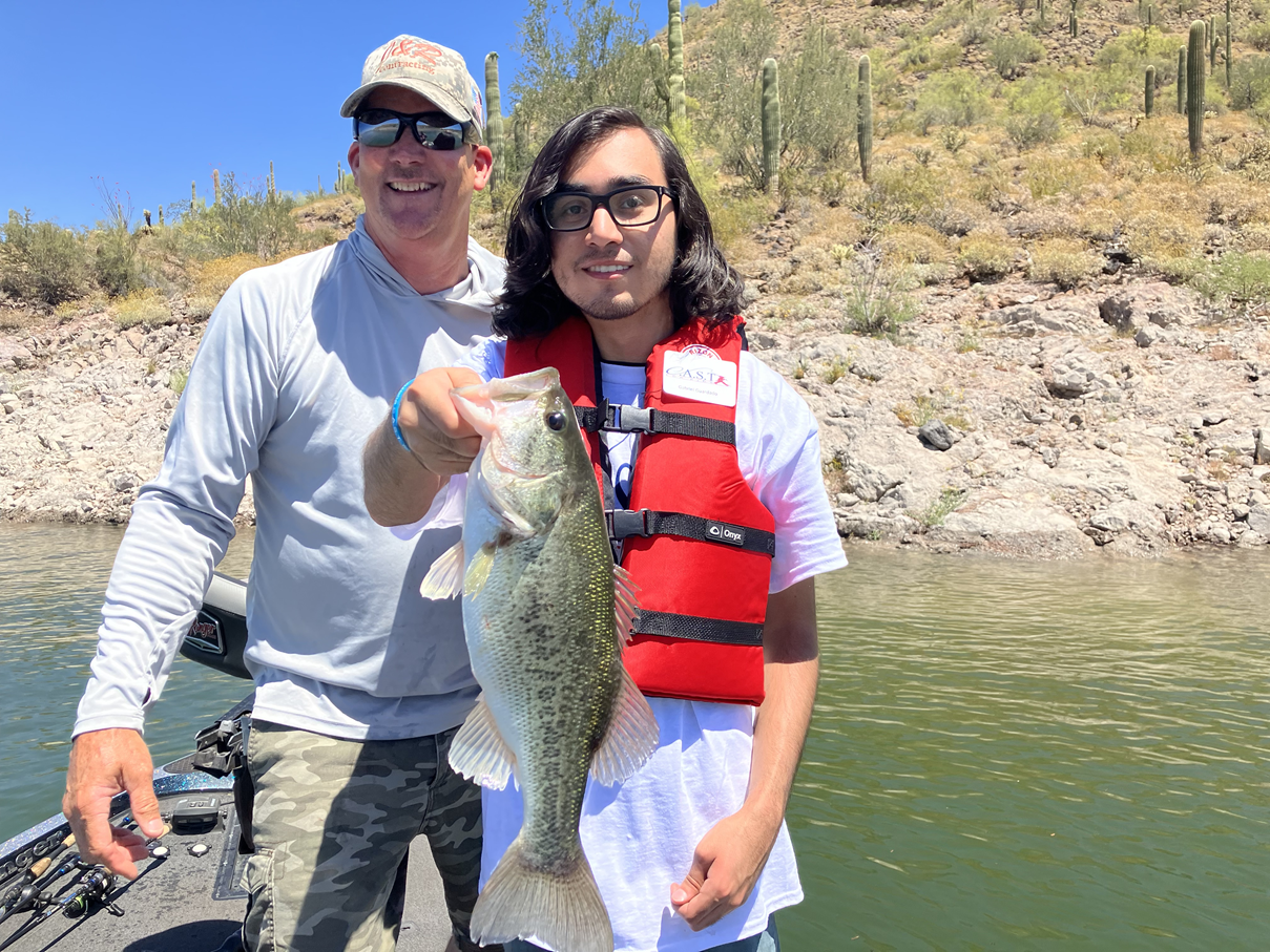 LakePleasant4 boy holding a fish with a life jacket on