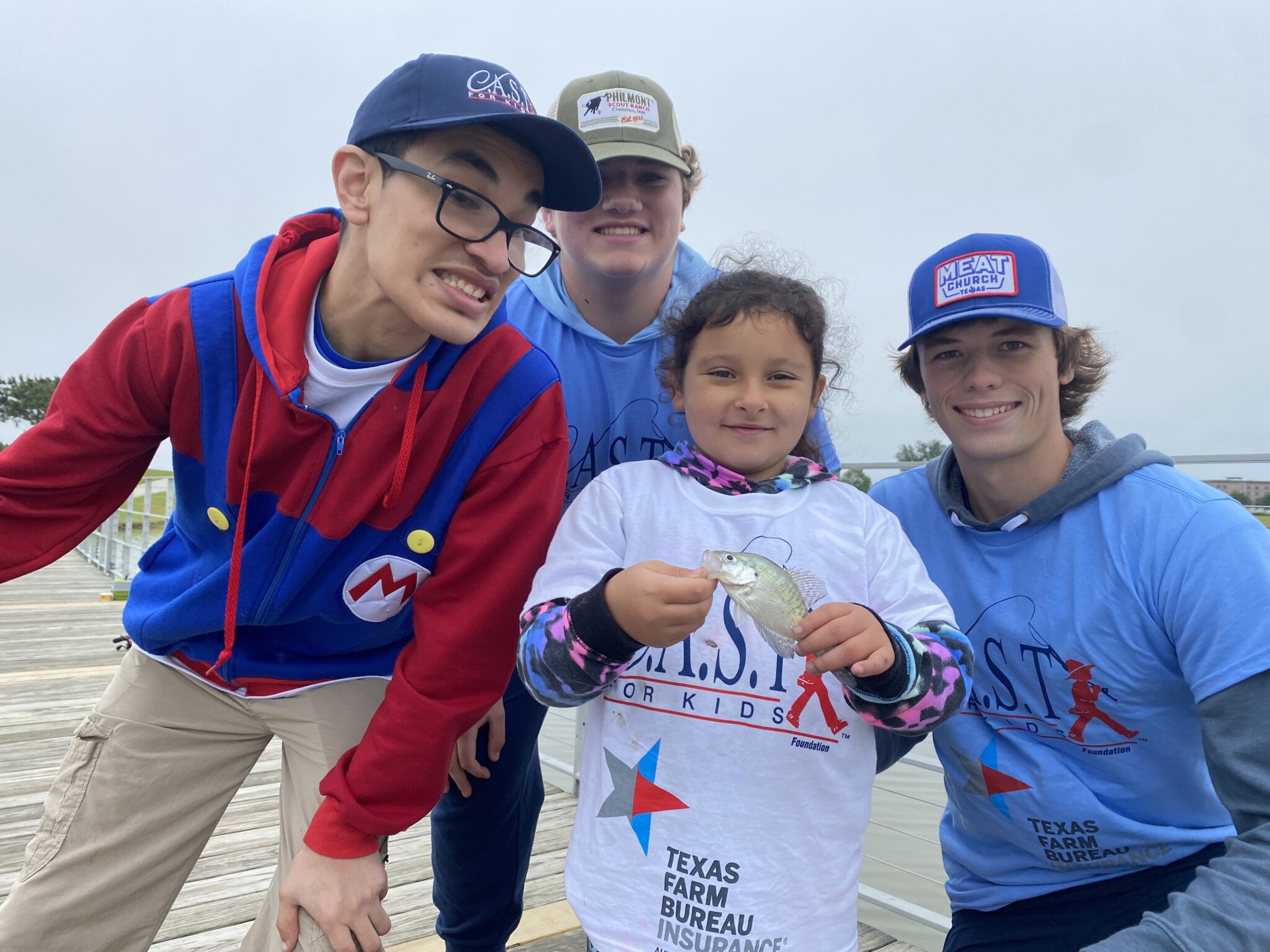 2024 CAST West Lake Website Photo (2) volunteers with a caught fish with young people