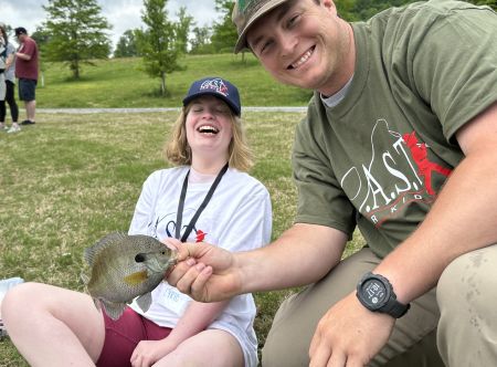 a kid holding a fish and pole