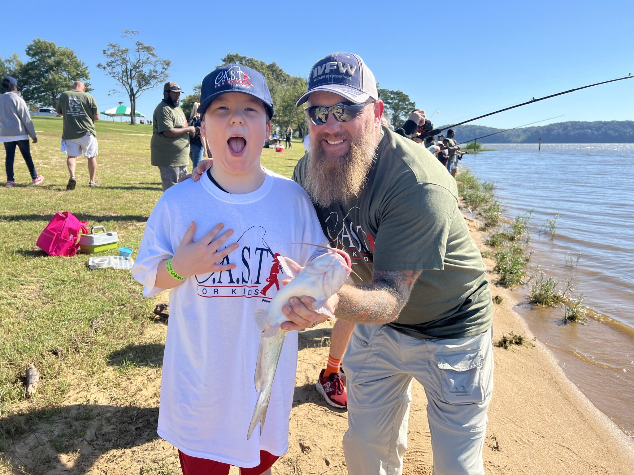 shore_vol_photo_on_vol_page kid with a volunteer fishing