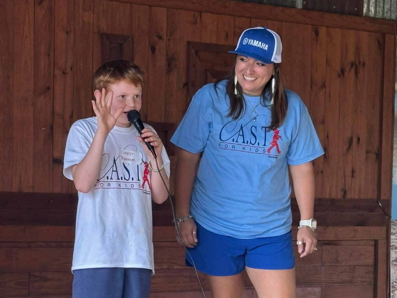 a kid holding a fish and pole