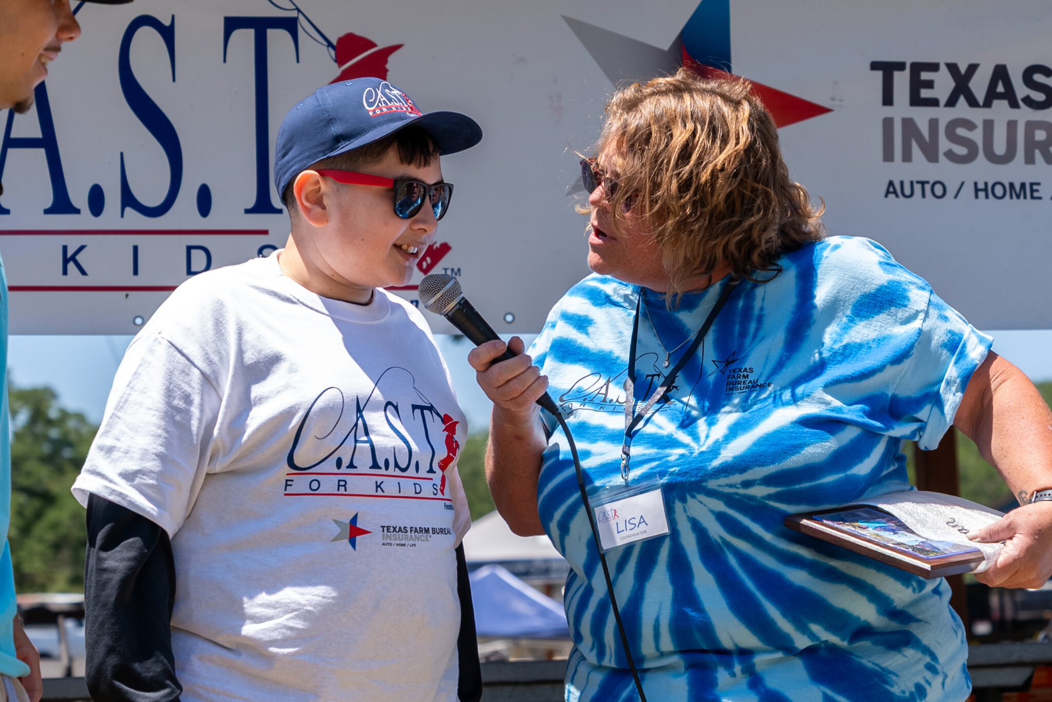 a woman with blue shirt interviewing person with microphone